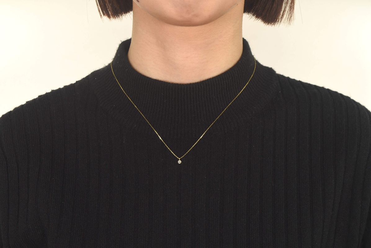 黒いセーターにゴールドネックレス
