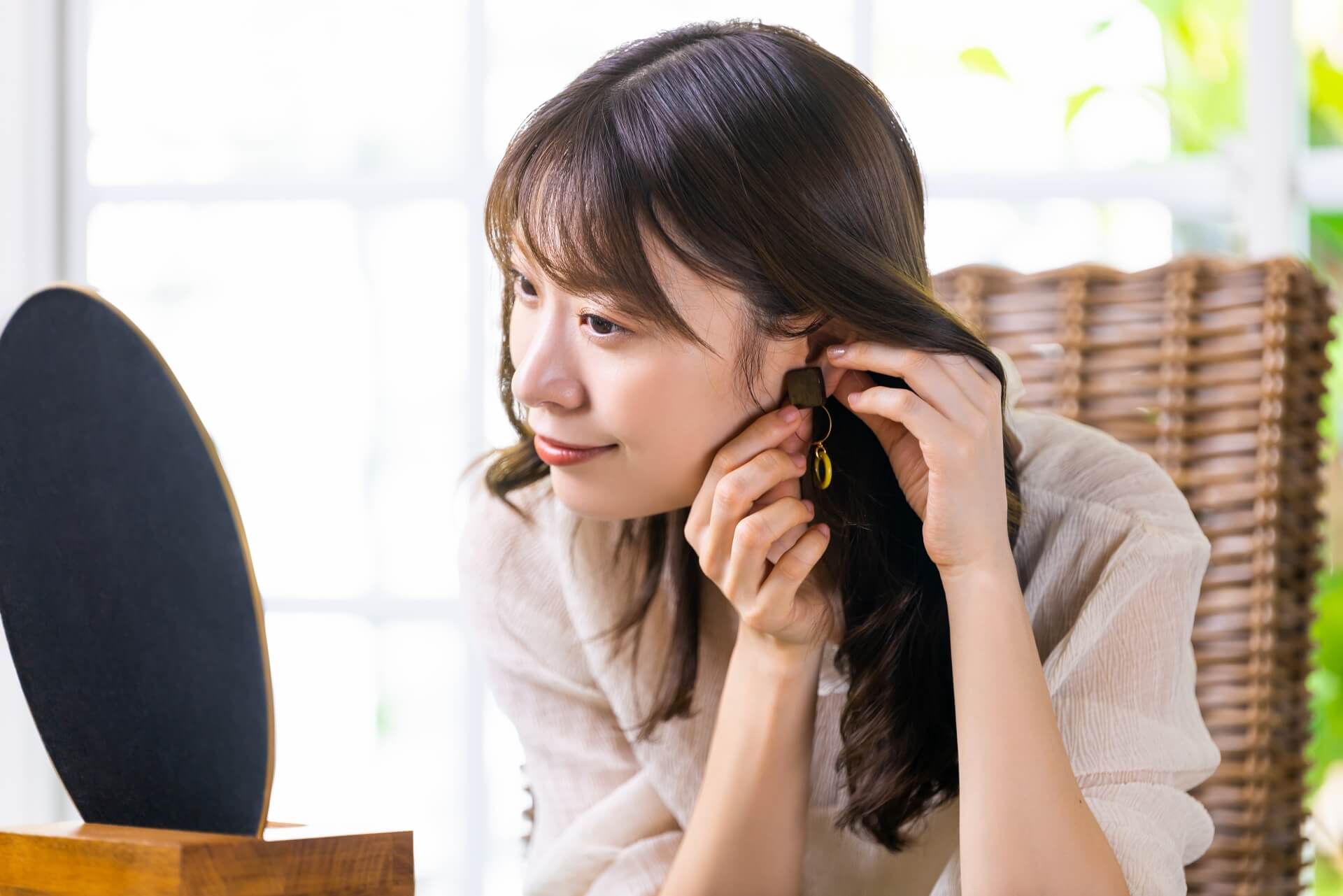 鏡の前でイヤリングをつける女性