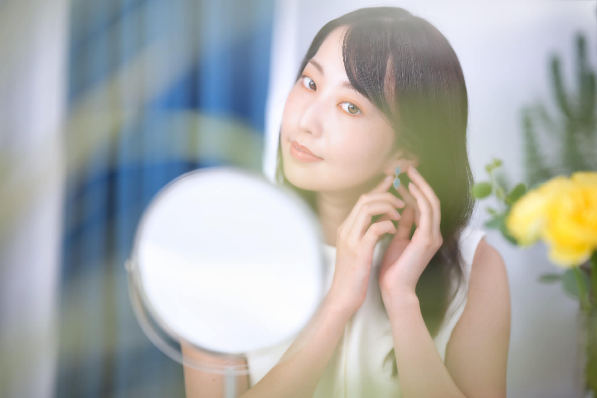 ミラー前でイヤリングをつける女性